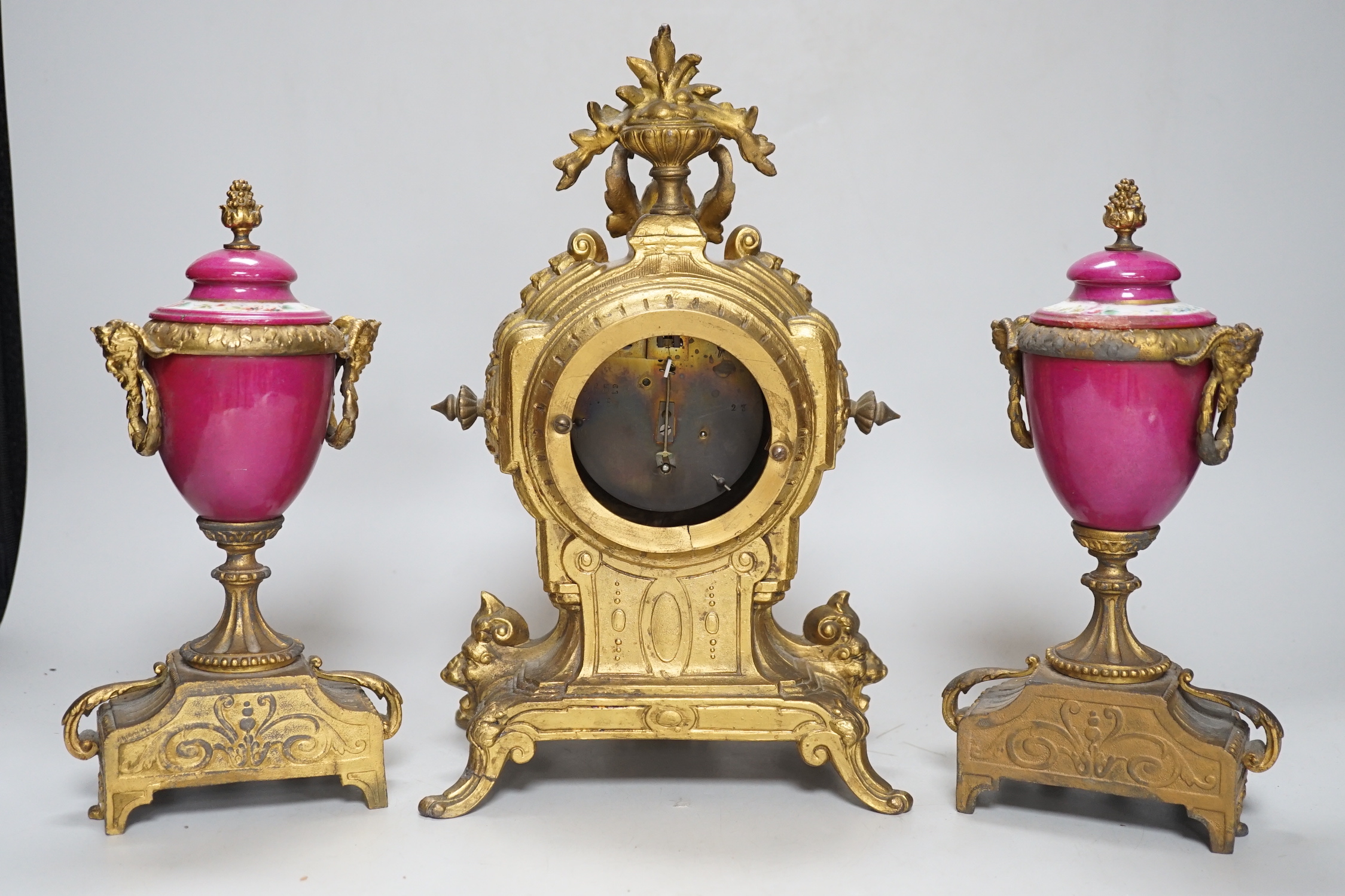 A 19th century porcelain mounted gilt spelter clock garniture, hand painted with landscapes, 30cm high